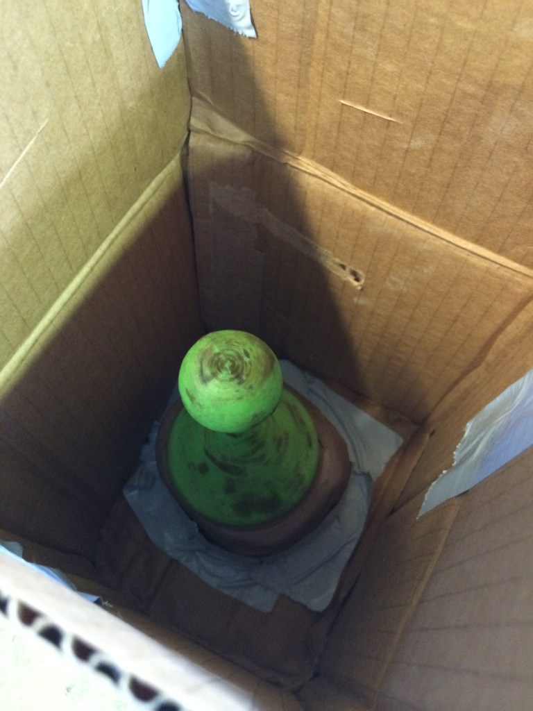 I used some wax to seal any  holes in the PLA Print, and then used a cardboard box to prep a form for casting plaster around the object. Note that I used some clay to fashion a resevoir/base for the 3D print. 